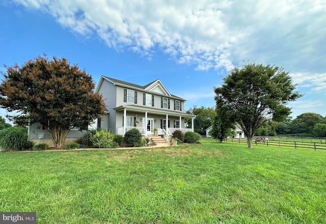 view of front of home featuring covered porch, fence, and a front lawn