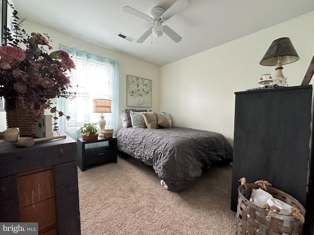 bedroom with ceiling fan, visible vents, and light colored carpet