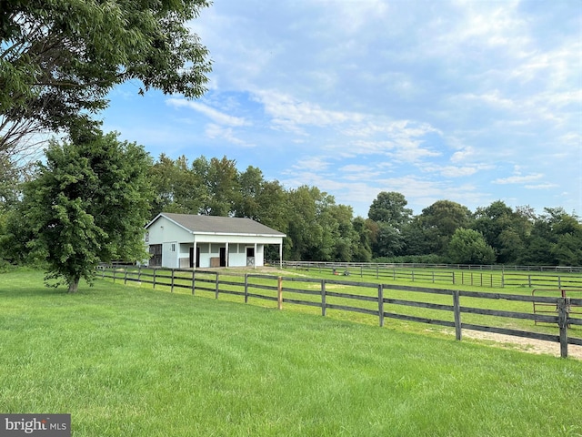 view of yard with an outbuilding and a rural view