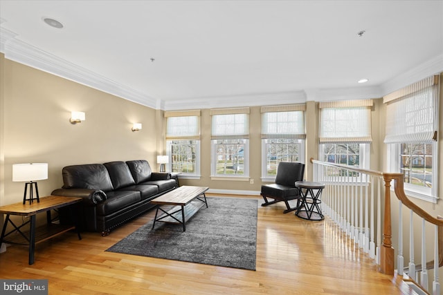 living area with crown molding and light wood-style floors