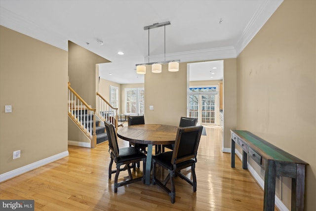 dining space featuring light wood finished floors, stairway, crown molding, and baseboards