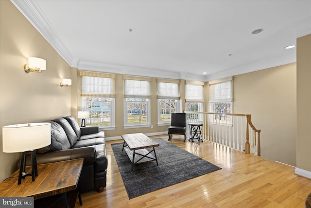 living room with wood finished floors, baseboards, and ornamental molding