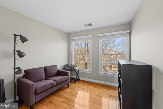 sitting room with baseboards, visible vents, and light wood-type flooring