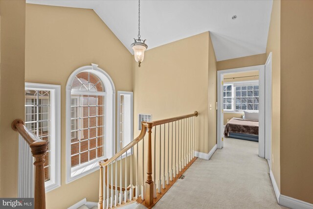 hallway with baseboards, an upstairs landing, carpet, and high vaulted ceiling