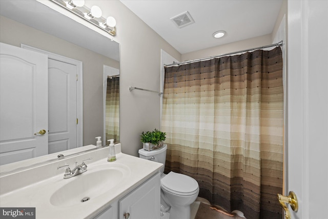 bathroom featuring vanity, toilet, and visible vents