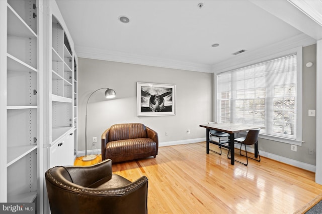 living area featuring visible vents, crown molding, baseboards, and wood finished floors