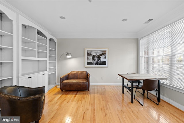 living area with light wood finished floors, visible vents, crown molding, and baseboards