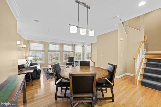 dining room with light wood-type flooring, ornamental molding, recessed lighting, baseboards, and stairs