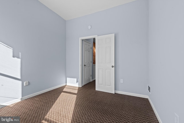 unfurnished room featuring carpet floors and baseboards