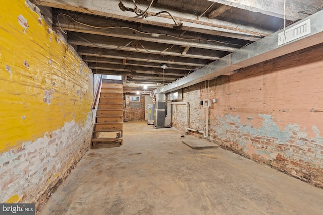 unfinished basement with visible vents and heating unit