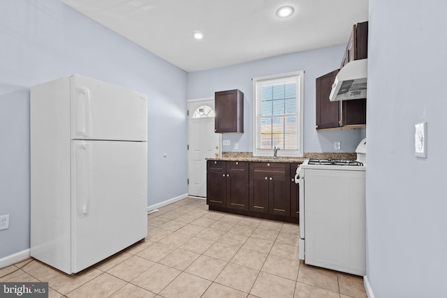 kitchen with light tile patterned floors, a sink, dark brown cabinets, white appliances, and under cabinet range hood