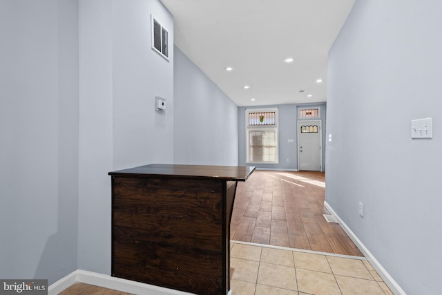 hallway featuring baseboards, light wood-style floors, visible vents, and recessed lighting