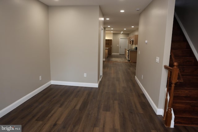 hallway with dark wood finished floors, stairway, recessed lighting, and baseboards