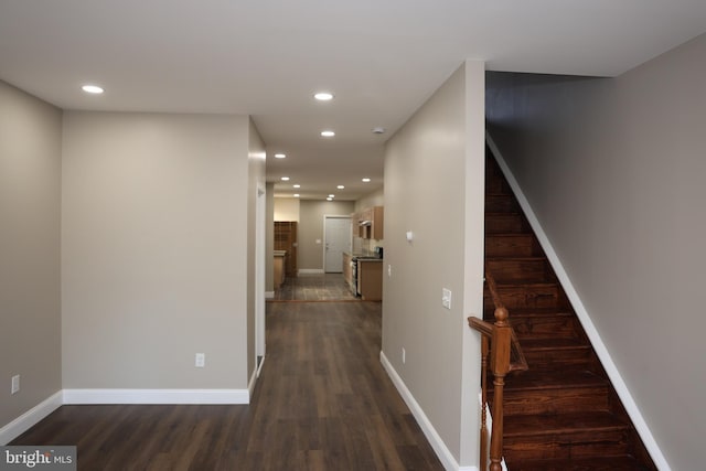 hallway featuring recessed lighting, baseboards, dark wood-style floors, and stairs