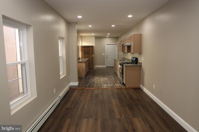 kitchen with under cabinet range hood, baseboards, stainless steel range with gas cooktop, and a baseboard radiator