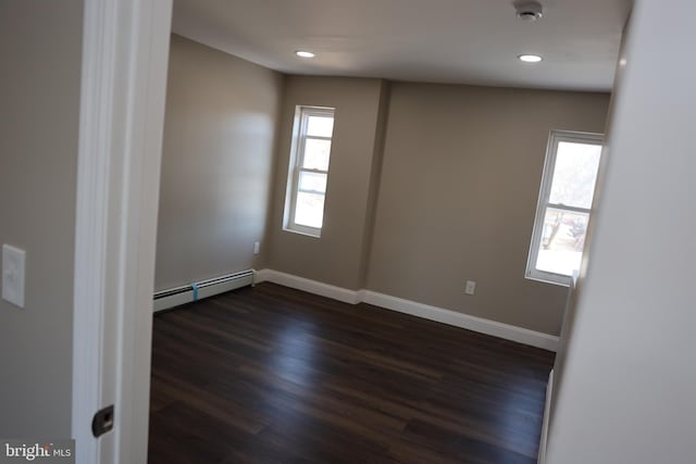 empty room with recessed lighting, dark wood-type flooring, baseboards, and a baseboard radiator