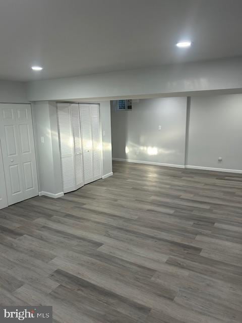 finished basement with recessed lighting, visible vents, baseboards, and wood finished floors