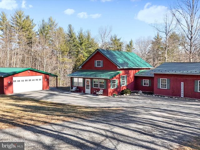 view of front of property featuring driveway, a garage, and metal roof