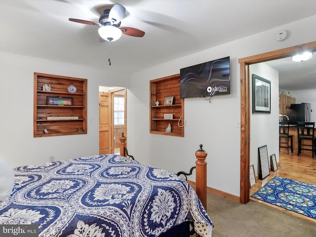 carpeted bedroom featuring a ceiling fan, freestanding refrigerator, and baseboards