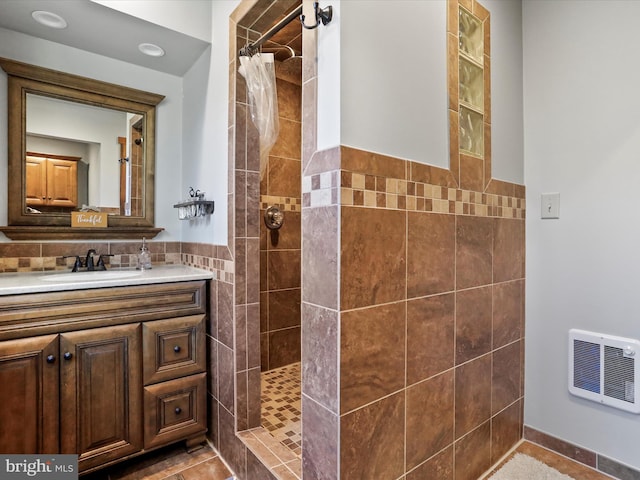 bathroom featuring a wainscoted wall, vanity, tile walls, tiled shower, and heating unit