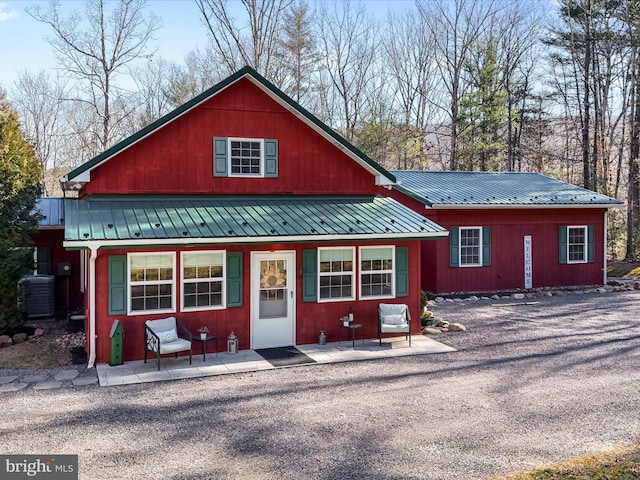 rustic home featuring metal roof and central air condition unit