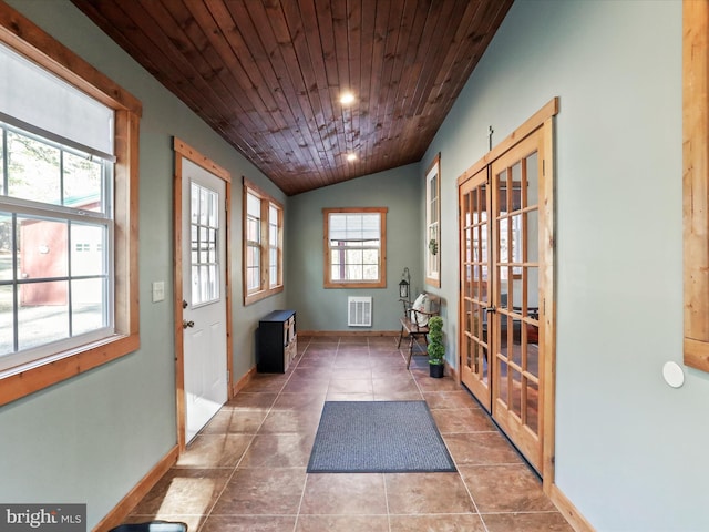 doorway to outside with baseboards, lofted ceiling, wood ceiling, tile patterned flooring, and french doors