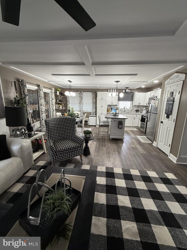 living room featuring a chandelier, dark wood-style flooring, coffered ceiling, and beam ceiling