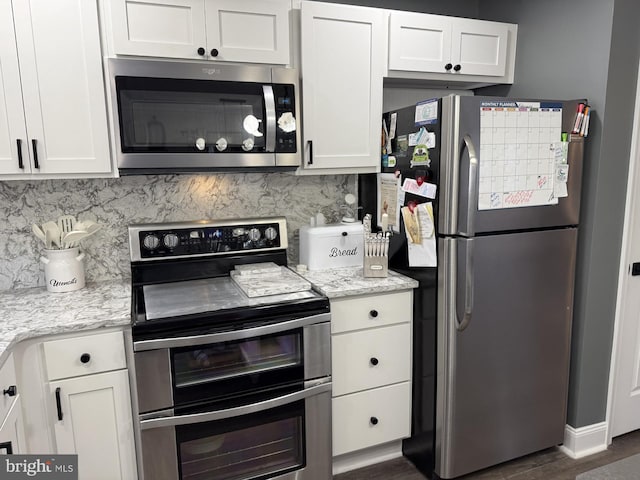 kitchen with appliances with stainless steel finishes, white cabinets, backsplash, and light stone countertops