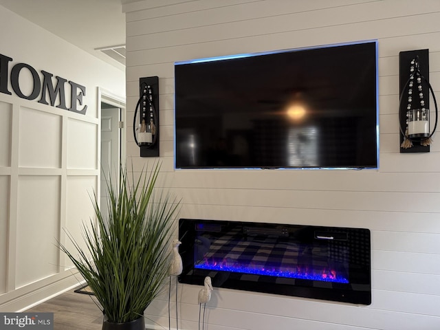 interior details with a glass covered fireplace and wood finished floors