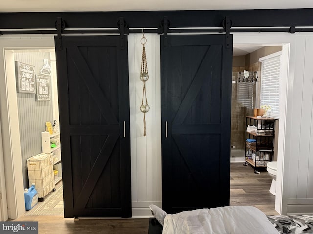 interior space featuring a barn door, wood finished floors, and baseboards