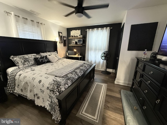 bedroom with dark wood-style floors, a ceiling fan, visible vents, and baseboards