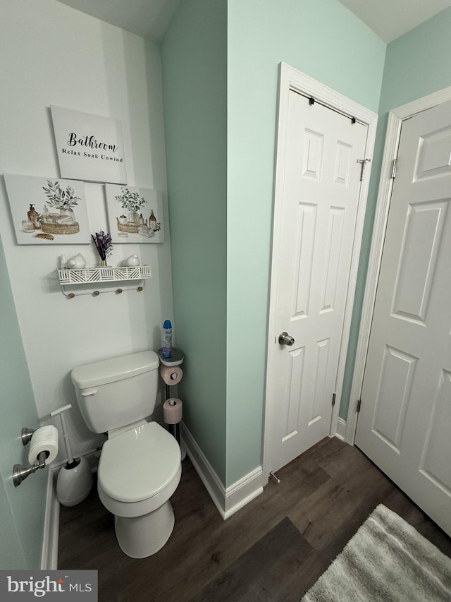 bathroom with wood finished floors, toilet, and baseboards