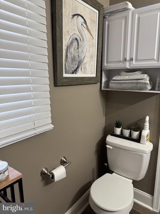 bathroom with toilet and baseboards