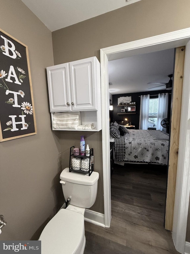 bathroom with toilet, ensuite bath, and wood finished floors