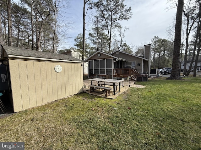 view of yard featuring a sunroom and an outbuilding