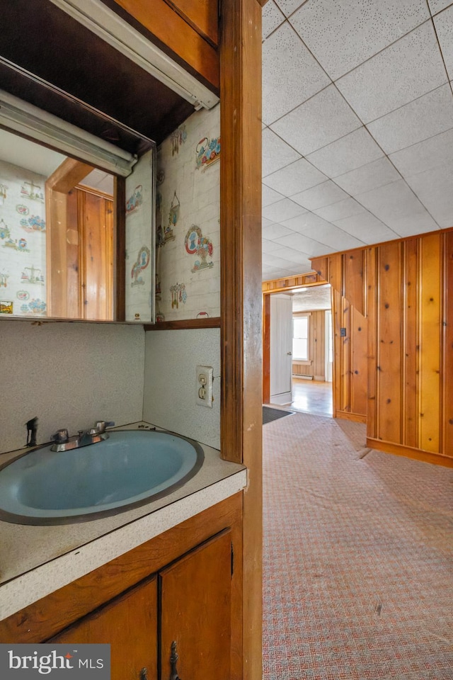 bathroom featuring wood walls and vanity