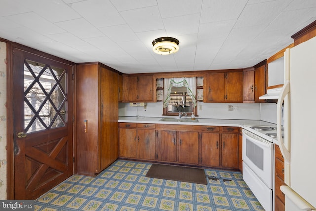 kitchen featuring light countertops, white appliances, tile patterned floors, and under cabinet range hood