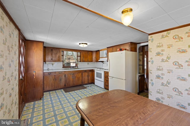 kitchen with tile patterned floors, white appliances, light countertops, and wallpapered walls