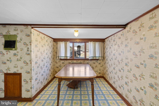 dining room with wallpapered walls, baseboards, and crown molding