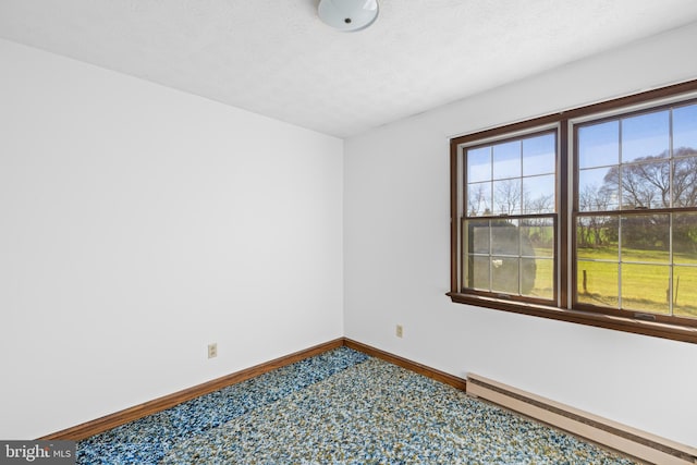 carpeted spare room featuring baseboards, a textured ceiling, and baseboard heating