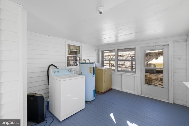 laundry room with water heater, laundry area, dark wood-style flooring, and washer / dryer