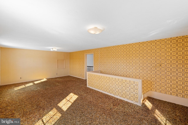 unfurnished room with carpet and wallpapered walls