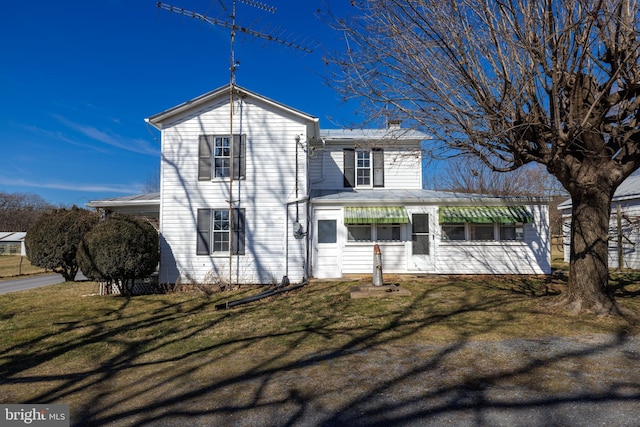 view of front facade featuring a chimney and a front lawn