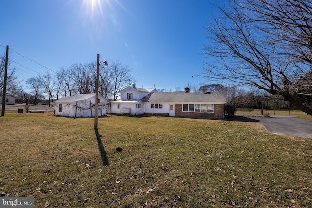 view of front of home with a front lawn and brick siding