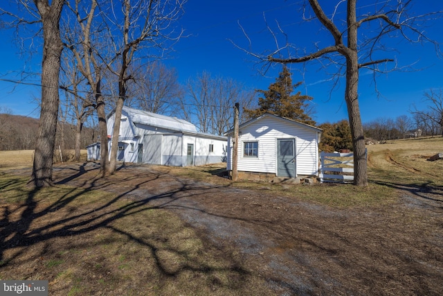 view of property exterior with a lawn and an outdoor structure