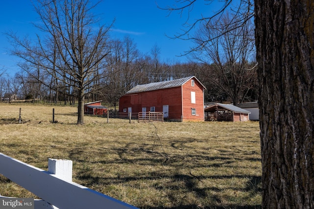 view of yard featuring a pole building, fence, and an outdoor structure