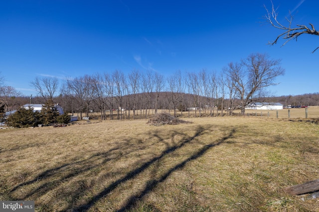 view of yard featuring fence and a rural view