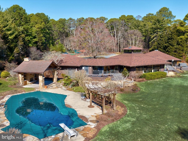 view of swimming pool featuring a covered pool, a yard, and a patio area