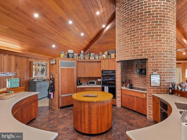 kitchen featuring black appliances, a center island, wooden walls, wooden ceiling, and light countertops