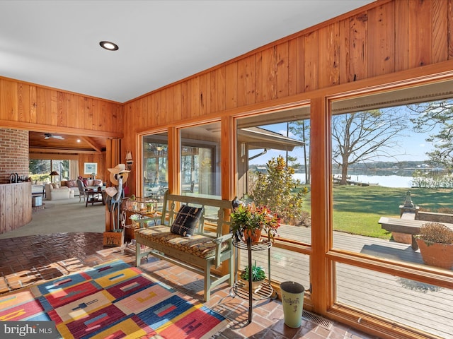 sunroom featuring a water view